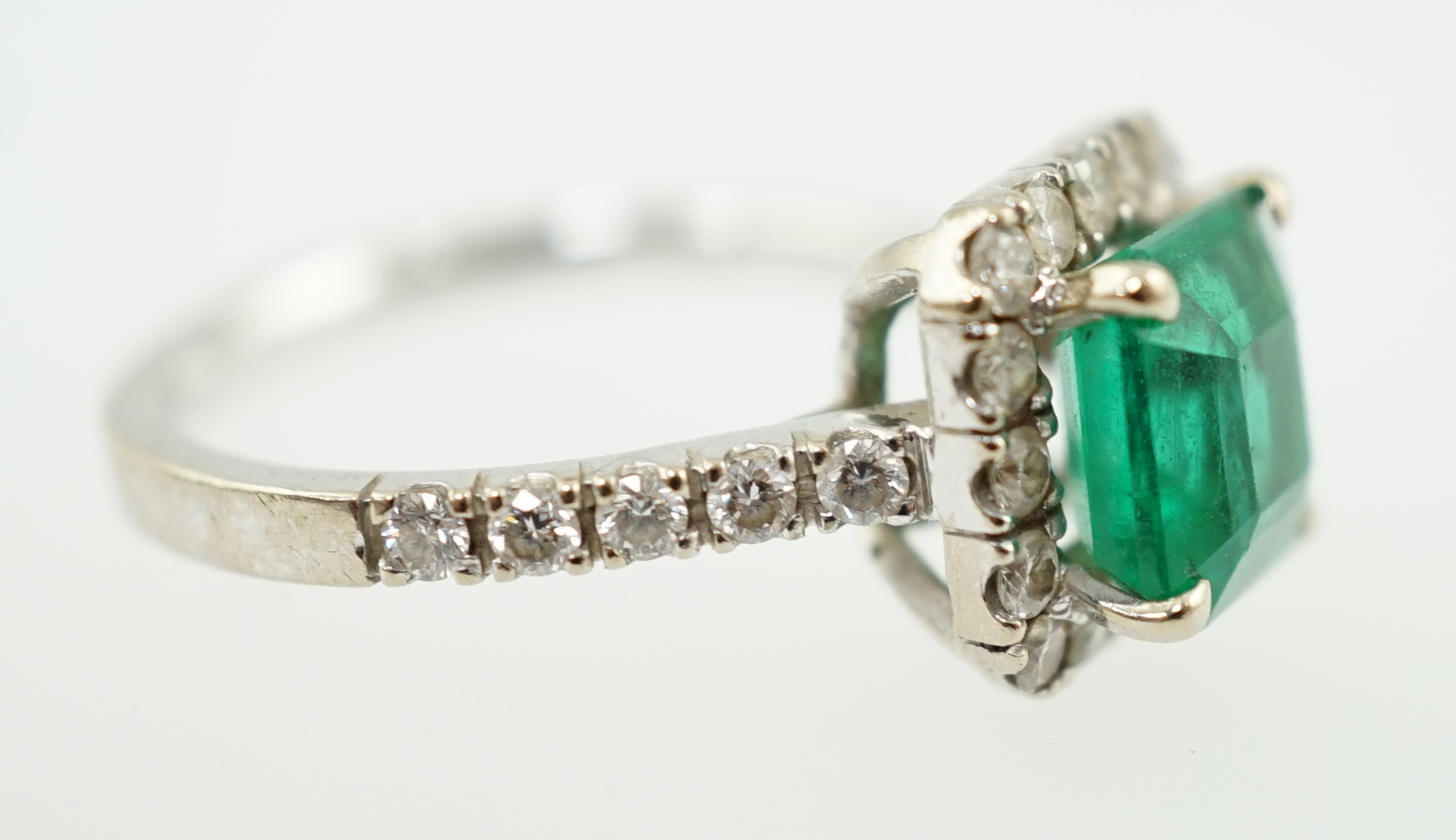 A modern 18k white gold, emerald and diamond set square cluster ring